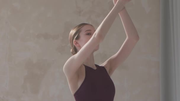 Bela jovem dançarina em preto palco vestido ensaiar movimentos de dança. Aula de dança em estúdio com piso em parquet branco. Fecha. Movimento lento. — Vídeo de Stock