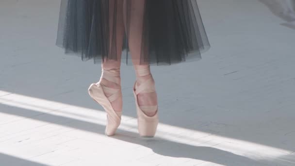 Balett táncosok lába, ahogy gyakorolja pointe gyakorlatok a fehér parketta padlóján. Közelről. Lassú mozgás.. — Stock videók