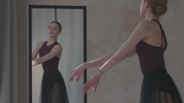 Zerbrechliche Ballerina probt vor einem Spiegel. Vorbereitung auf den Auftritt. Gedreht in einem hellen und sonnigen Studio. Aus nächster Nähe. Zeitlupe. — Stockvideo