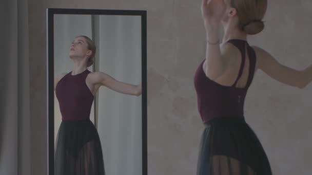 Zerbrechliche Ballerina probt vor einem Spiegel. Vorbereitung auf den Auftritt. Gedreht in einem hellen und sonnigen Studio. Aus nächster Nähe. Zeitlupe. — Stockvideo