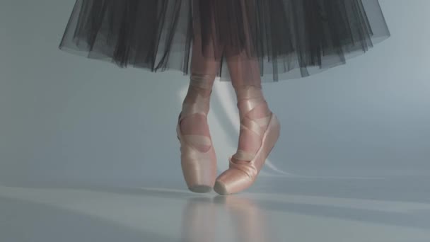 身着黑色透明裙子的芭蕾舞演员们展示了经典的芭蕾表演.芭蕾舞蹈演员在白色的地板上练习指尖练习时,她的脚也是这样跳的.靠近点慢动作. — 图库视频影像