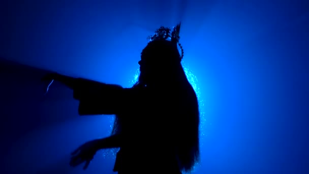 Silueta negra de una mujer en la corona de una princesa china sobre un fondo azul brillante. Movimientos suaves de manos. De cerca.. — Vídeos de Stock