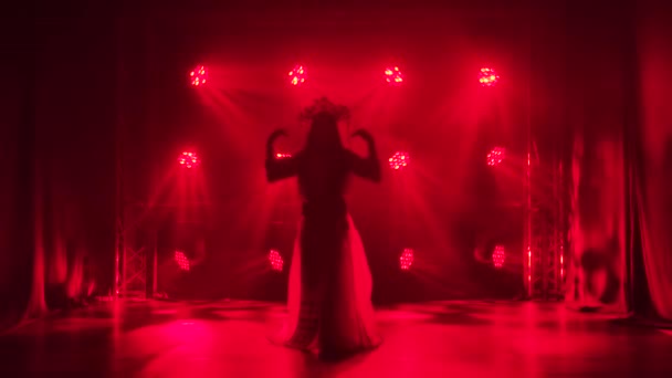 Tanečnice se rýsuje v červených světlech a kouří při lidovém tanci. Jasná bruneta v červeném hedvábném obleku a čelenka čínské princezny. Zpomalený pohyb. — Stock video