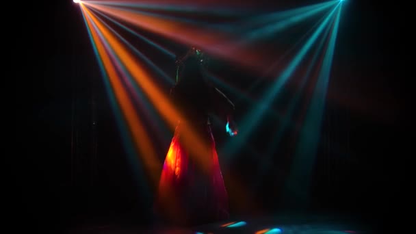 Silueta delgada de una princesa china en tocado elegante y un vestido de seda rojo. La mujer está haciendo el baile de su gente. Filmado en una habitación oscura con luces mágicas de estudio y humo. Movimiento lento. — Vídeos de Stock