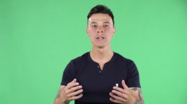 Yakışıklı bir gencin portresi kameraya beklentiyle bakıyor ve sonra çok üzgün. Yeşil Ekran.