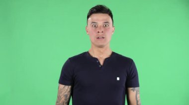 Korku ve dehşetle kameraya bakan yakışıklı bir gencin portresi. Yeşil Ekran.