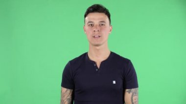 Yakışıklı bir gencin portresi kameraya bakıp taş gibi bir jest yapmak ve hayattan zevk almaktır. Yeşil Ekran.