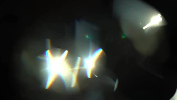 Krásné světlo prosakuje na tmavém pozadí s reálným objektiv světlice. — Stock video