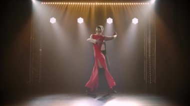 Ağır çekimde tangodan dans öğesi. Dumanlı bir stüdyoda genç bir çift tarafından yapılan zarif bir Latin Amerika dansı..