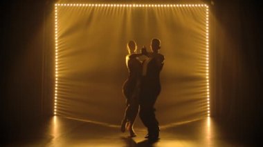 Karanlık bir stüdyoda tango yaparken birkaç dansçı vücutlarını birbirine sıkıca bastırıyor. Tutkulu dansçıların siluetleri ağır çekimde dansın tadını çıkarıyor..