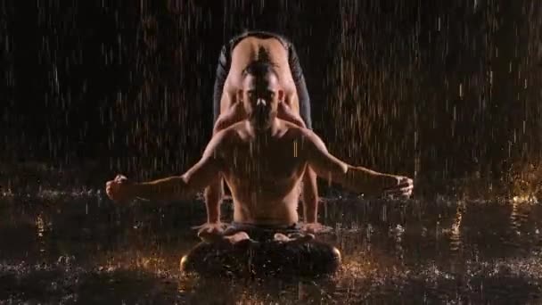Akrobatikus show az esőben három profi férfi művész előadásában. A víz felszínén lőtték le egy sötét stúdióban. Lassú mozgás. Közelről.. — Stock videók
