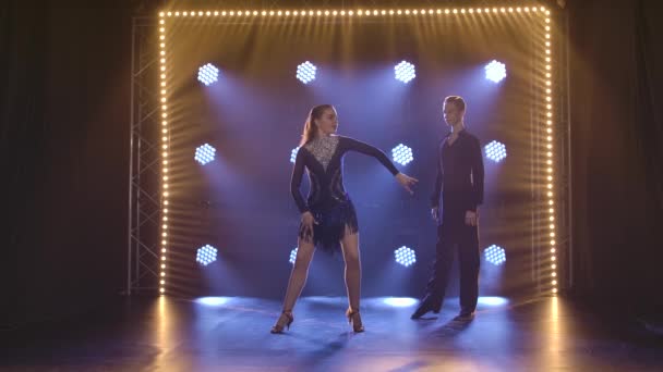 Δυο νεαροί χορευτές που χορεύουν παθιασμένα Λατινοαμερικάνικα cha cha cha. Επαγγελματίες χορευτές σε καπνιστό φόντο με μπλε φως. Αργή κίνηση. — Αρχείο Βίντεο