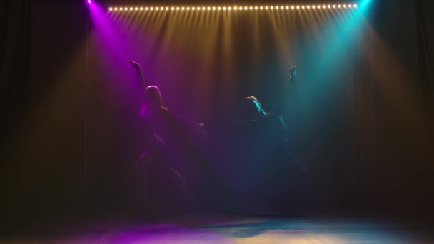 Χορός σε αίθουσα χορού από ένα νεαρό παθιασμένο ζευγάρι. Σιλουέτα ανδρών και γυναικών σε σκοτεινό στούντιο με σκηνοθετημένο φως. Αργή κίνηση. — Αρχείο Βίντεο