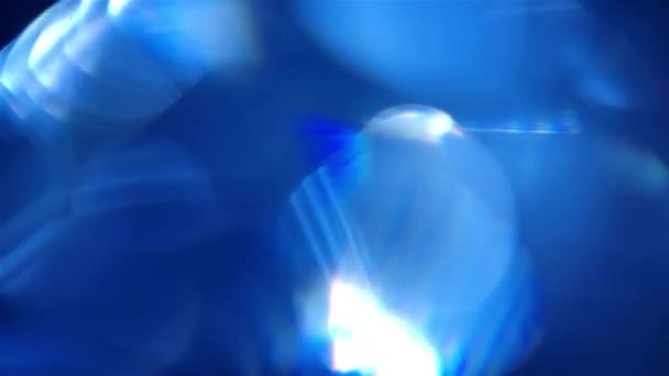 Reflejos perlescentes y brillo. Destellos de luces azules que se reflejan en la gema del diamante. Círculos Bokeh fondo de cerca en cámara lenta. — Vídeo de stock