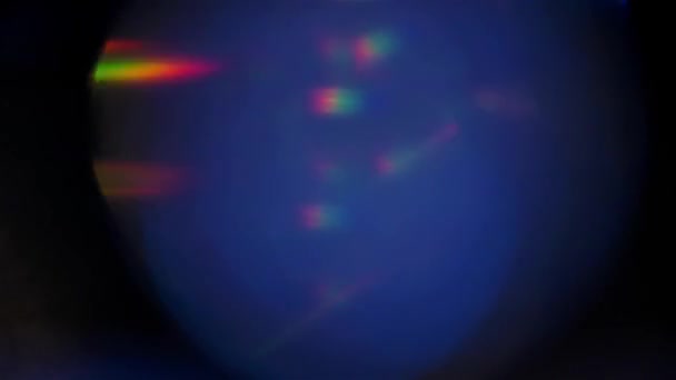 Glanzend neon veelkleurig studiolampje in diamantfacetten. Bokeh cirkels achtergrond met sprankelende lens flare en regenboog kleuren close-up in slow motion. — Stockvideo