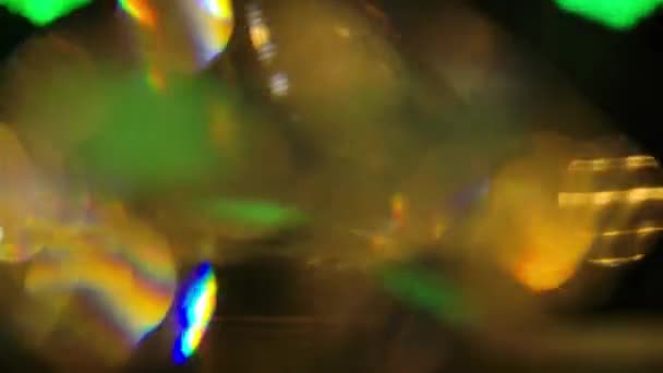 Des reflets émeraude et des fusées éclairantes multicolores se reflètent sur les visages d'un diamant qui tourne lentement sur un fond noir. Tourné sur un fond noir gros plan au ralenti. — Video