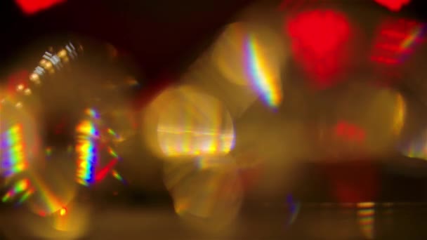 Los destellos brillantes de las luces de neón del estudio reflejan los bordes del diamante giratorio para crear reflejos iridiscentes. Círculos bokeh multicolores fondo de cerca en cámara lenta. — Vídeo de stock