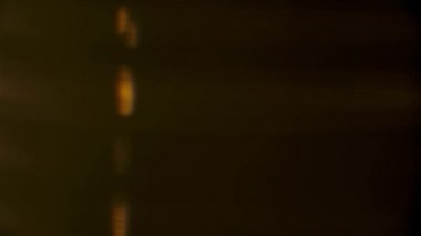 Yanardöner mercek parlıyor ve arka plan parıldıyor. Stüdyo ışığı yavaşça dönen elmasın kenarlarından geçer ve yumuşak prizmatik yansımalar yaratır. Ağır çekim. Kapat..