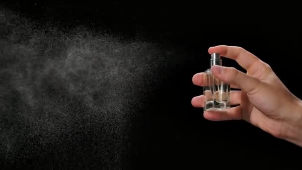 Un hombre rocía un aerosol de alcohol higiénico para la desinfección y prevención de COVID 19. Salpicaduras en un fondo negro de cerca en cámara lenta. — Vídeos de Stock