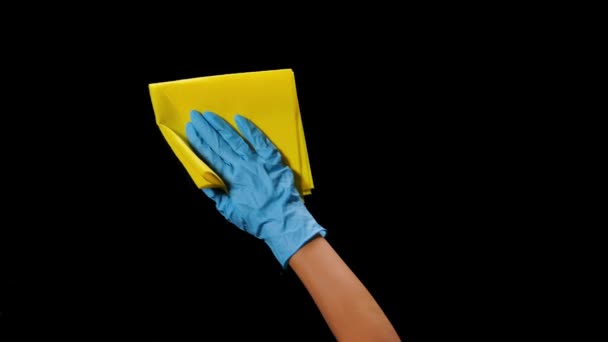 Een man met beschermende handschoenen desinfecteert een glazen oppervlak van covid 19. Antibacteriële reiniging met een desinfecterend middel tegen een gevaarlijke coronavirusziekte. close-up in slow motion op een zwarte achtergrond. — Stockvideo