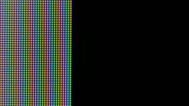 Piksele powiększyły się o czerwone, niebieskie i zielone świecące kryształy i wzory na monitorze graficznym komputera. Piksele pojawiają się, a następnie znikają na ekranie. — Wideo stockowe