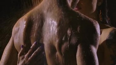 Duşta birlikte yıkanırken sarılan güzel bir çift. Aşıklar geceleri birbirlerini severler. Islak vücutlar yakınlaşır. Yavaş çekim.