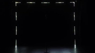 Eski mikrofon eski usul. Klasik bir konser mikrofonu karanlık bir stüdyoda duman ve flaş ışıklarına karşı tek başına duruyor..