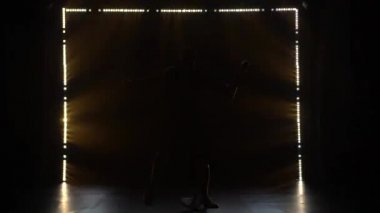 Parlak renkli flaş ışıkları olan karanlık bir stüdyoda erkek vokalistin rock performansı. Garip davranan ve kafasını sallayan bir adamın silueti..