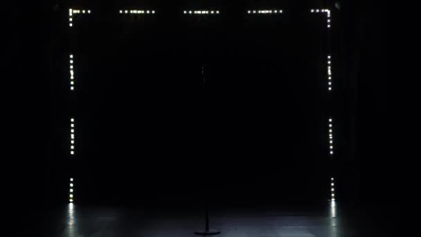 Old microphone in retro style. A classic concert microphone stands alone in a dark studio against a backdrop of smoke and strobe lights. — Stock Video
