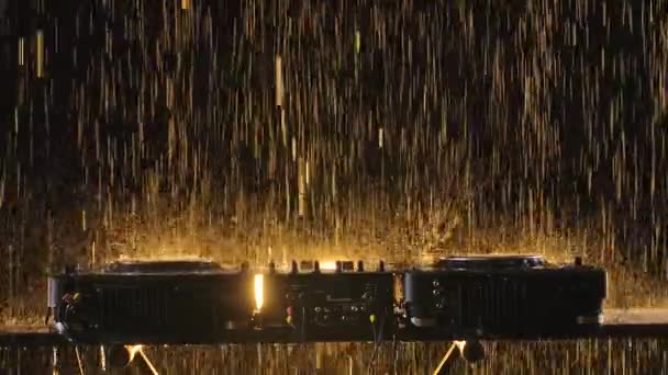 Professionelles Mischpult zum Abspielen von Tanzmusik in einem dunklen Studio mit Bühnenbeleuchtung. Brillanter Regen fällt auf das DJ-Deck. Aus nächster Nähe. Zeitlupe. — Stockvideo