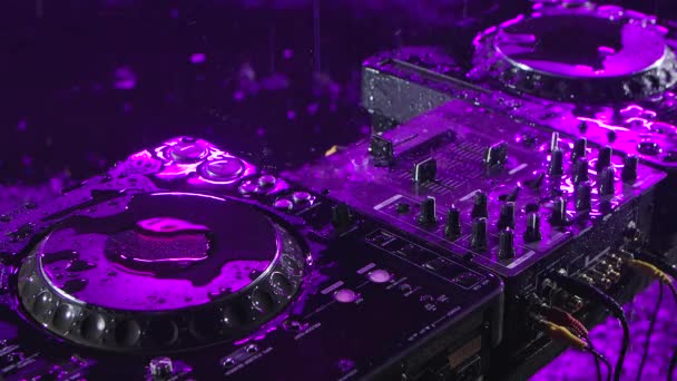 Audio mixing controller stands in a dark studio with purple illumination. DJ tools in the pouring rain. Top view. Close up. Slow motion. — Stock Video