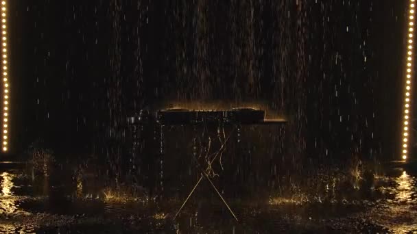 Wet from the rain Pro dj controller. The DJ console deejay mixing desk and professional headphones against the background of a dark studio under drops of rain. Slow motion. — Stock Video