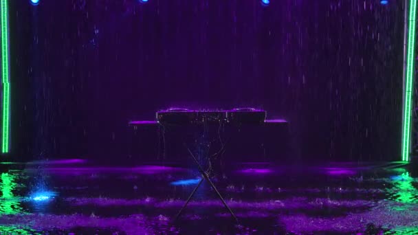 Club disc jockey stage equipment for playing music on party. Professional concert dj turntables player device in the rain on the background of a dark studio with backlight. Slow motion. — Stock Video