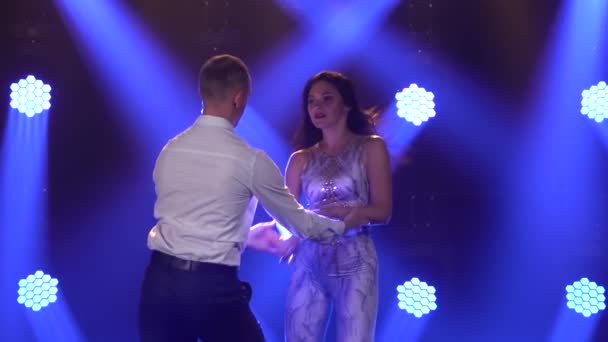 Flexibele en sensuele dansers dansen in een donkere zaal met blauwe spots op de achtergrond. Latijnse dans. Salsa. Bachata. Langzame beweging. Sluiten.. — Stockvideo