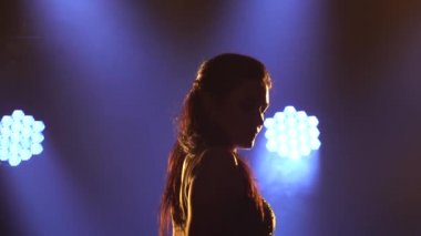İnce bir kadın dansçı kalçasını salsa dansının hareketlerine alıştırma yaparak hareket ettirir. Parlak elbiseli bir kadın ağır çekimde hareket ediyor. Yakın çekim..
