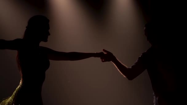 Молодой привлекательный мужчина и женщина танцуют латиноамериканский танец в костюмах в студии, замедленная съемка, крупный план. Профессиональное исполнение сальсы. — стоковое видео