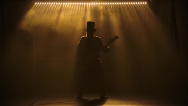 Il chitarrista si esibisce sul palco. Prestazioni al rallentatore. Un uomo con un cappello con la barba sta suonando energicamente la chitarra elettrica. Concerto metal o rock. Live show. — Video Stock