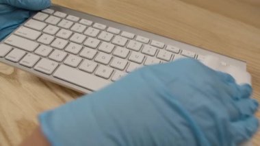 Ofisteki masaüstü klavyesini temizlemek, hijyen konseptini korumak ve koronavirüsle savaşmak. Antibakteriyel mendil kullanarak nesnelerin yüzeyini temizliyorum. Kapatın. Yavaş çekim.