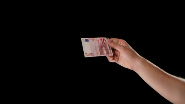 A man holds a 10 euro bill and treats it with disinfectant. Sterilization of money from germs and viruses to prevent the spread of the COVID-19 coronavirus epidemic. Close up. Slow motion. — Stock Video