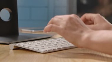 Bir kadın ofis masasında ya da evinde oturan bir bilgisayarın beyaz klavyesine yazı yazıyor. İş için bilgisayar kullanmak, hızlı yazmak ya da iletişim kurmak. Kapatın. Yavaş çekim.