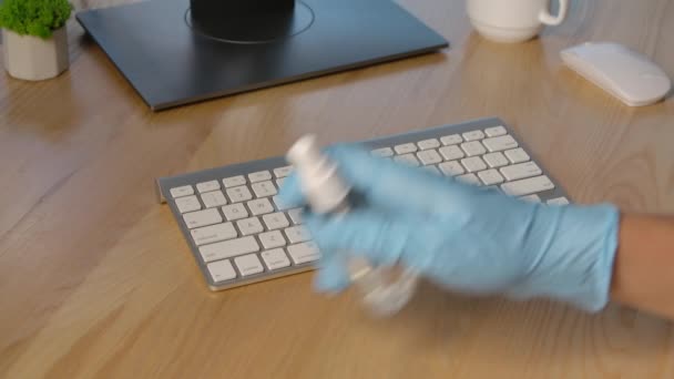 Les mains dans des gants de latex protecteurs pulvérisent un antiseptique sur la surface du clavier et le nettoient soigneusement des virus, germes et bactéries dangereux avec une serviette. Ferme là. Mouvement lent. — Video