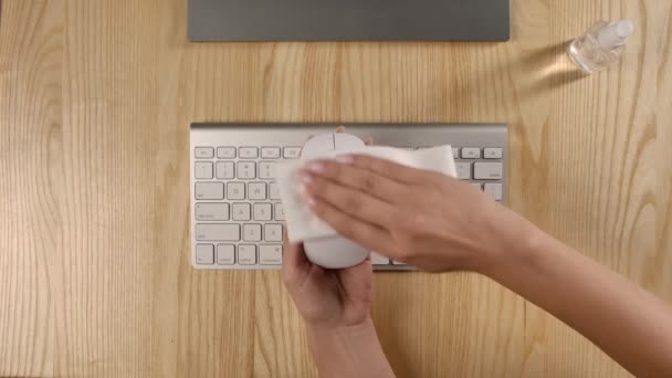 Vue aérienne de mains féminines nettoyant une souris d'ordinateur avec un désinfectant antibactérien essuyez et antiseptique pour détruire le coronavirus. Ferme là. Mouvement lent. — Video