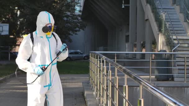 L'uomo disinfetta corrimano covid-19 mers. Disinfezione da virus influenzale Corona. Disinfettante del coronavirus. Gli operai indossano l'uniforme bianca. Proteggete la tuta. Disinfettante spray rotante. Lavoro pericoloso. Al rallentatore. Da vicino.. — Video Stock