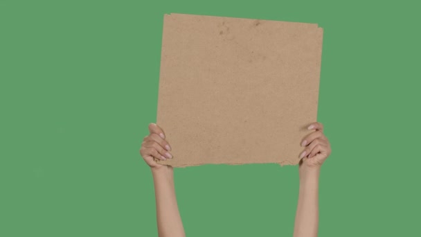 Protesto espaço de cópia de banner. As mãos femininas estão segurando papelão em branco. Plataforma de publicidade. Isolado uma tela verde, chave chroma. Fecha. Movimento lento. — Vídeo de Stock