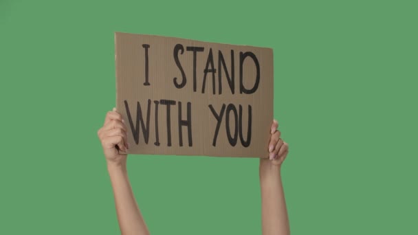 展示印有题词的纸板海报我和你站在一起。Human Rights Demonstration.手拿着海报,绿色屏幕,色键.靠近点慢动作. — 图库视频影像
