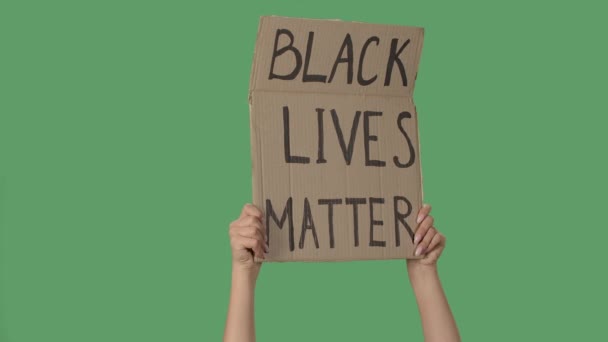 Manifesto di protesta con la scritta BLACK LIVES MATTER. Contesto per illustrare il movimento per la libertà dei diritti umani. Mani femminili che tengono poster verde chiave cromatica dello schermo. Chiudete. Rallentatore — Video Stock