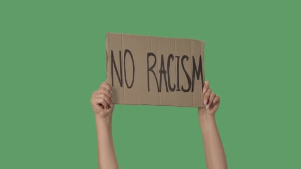 Üzerinde RACISM HAYIR yazan bir protesto posteri. İnsan hakları hareketini resmetmek için arka plan. Poster yeşil ekranı tutan kadın eller, kroma anahtar. Kapatın. Yavaş çekim. — Stok video