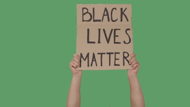 Mostrando cartaz de papelão com inscrição BLACK LIVES MATTER. Demonstração dos Direitos Humanos. Mãos segurando um cartaz uma tela verde, chave chroma. Fecha. Movimento lento. — Vídeo de Stock