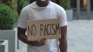 Bir Afro-Amerikalı caddenin ortasında elinde 