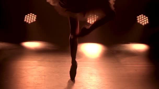 穿着白尖鞋的芭蕾舞演员优雅的腿。芭蕾舞演员表演经典的芭蕾舞剧.在摄影棚的聚光灯背景下在黑暗中拍摄。靠近点慢动作. — 图库视频影像